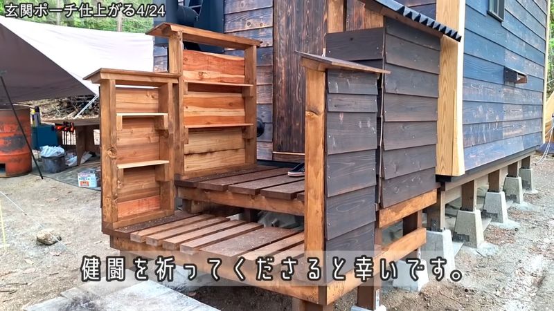 小屋の外壁と同じ板を張った靴箱と手すり棚