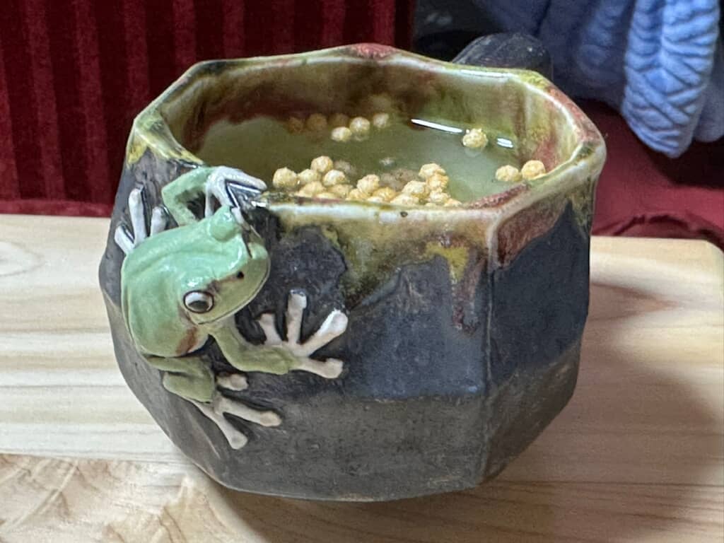 カップについたカエルのオブジェ