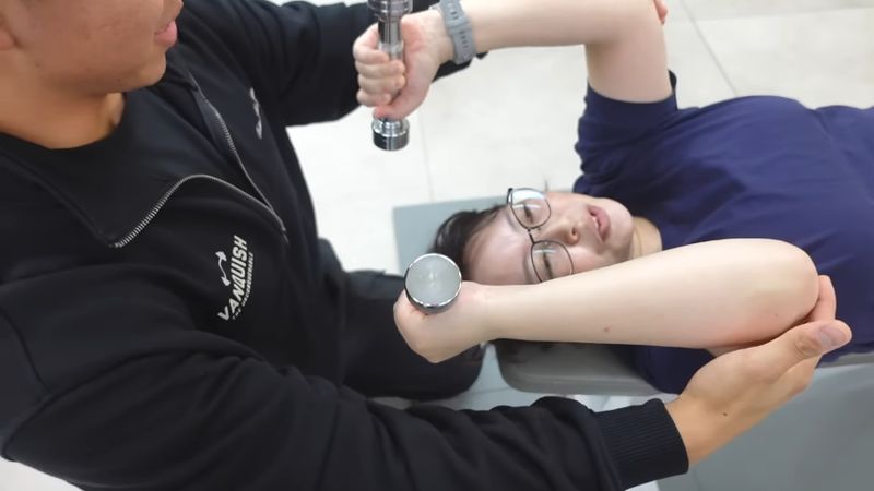 パーソナルトレーナーにダンベルを使ったトレーニングを教わるウニさん