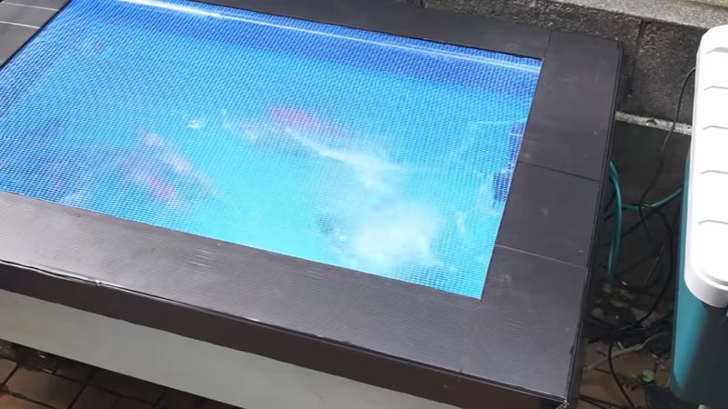 中央をくり抜き青いネットを張った雨どいろ過器のフタ