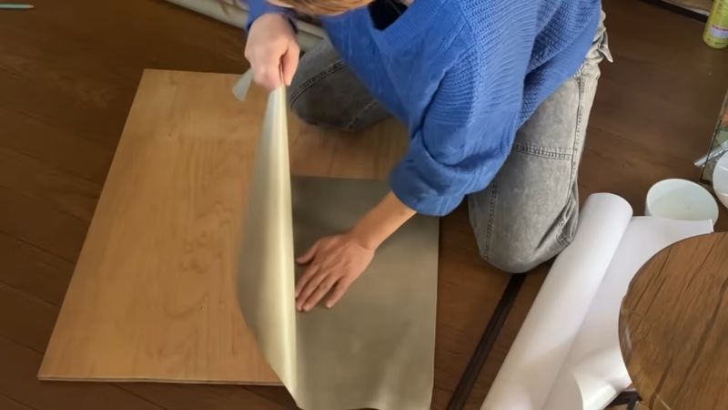 コンパネにカッティングシートを貼る様子