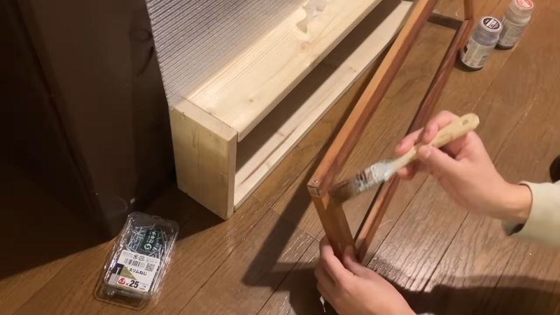 ニスで扉と棚を塗装する様子