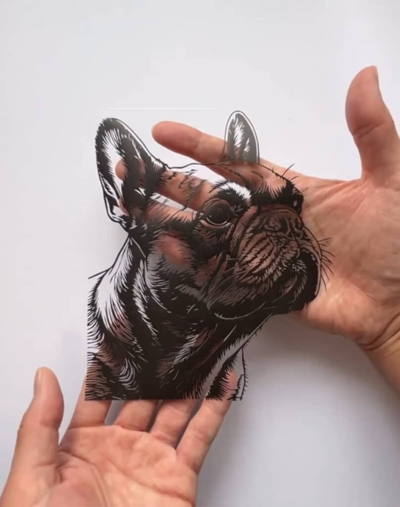 両手で切り絵を持ち上げる様子