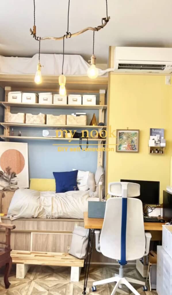 ロフトベッドの下にデスクとソファを配置した完成イメージ。天井には流木風のバーに吊られた3つの裸電球照明。