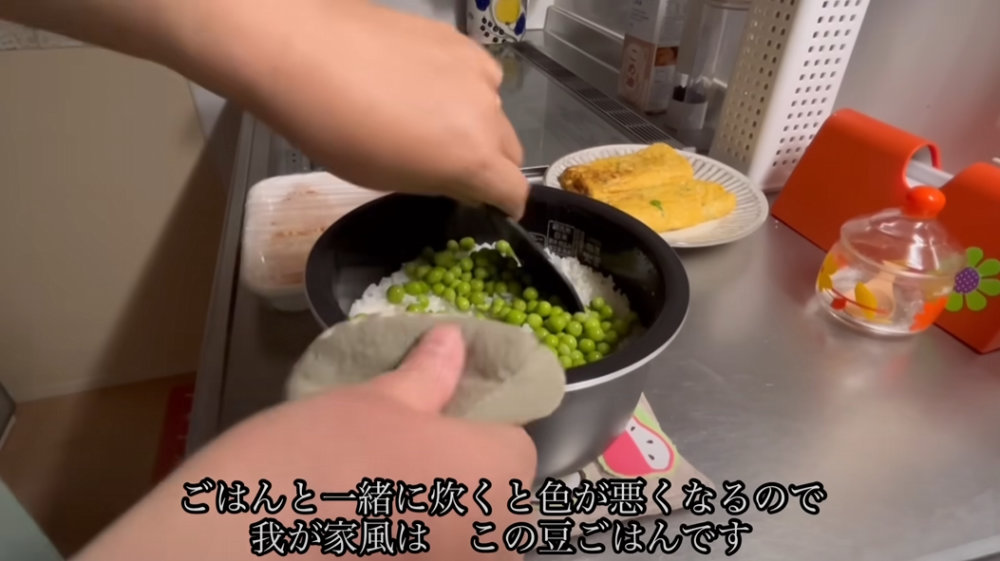 豆のゆで汁と出汁で炊いたごはんに豆を入れて混ぜる様子