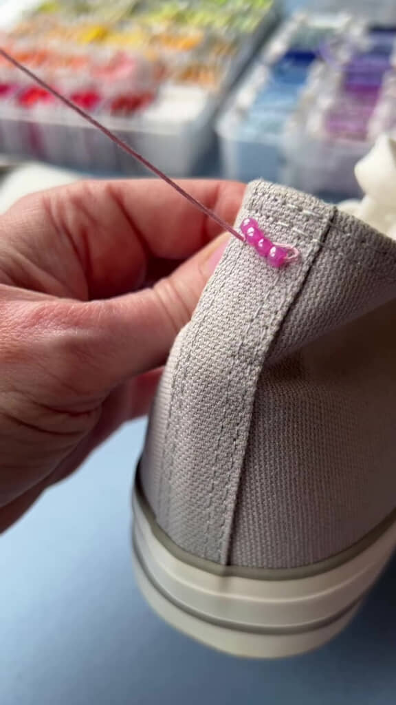 スニーカーにビーズを4個縫い付けているところ