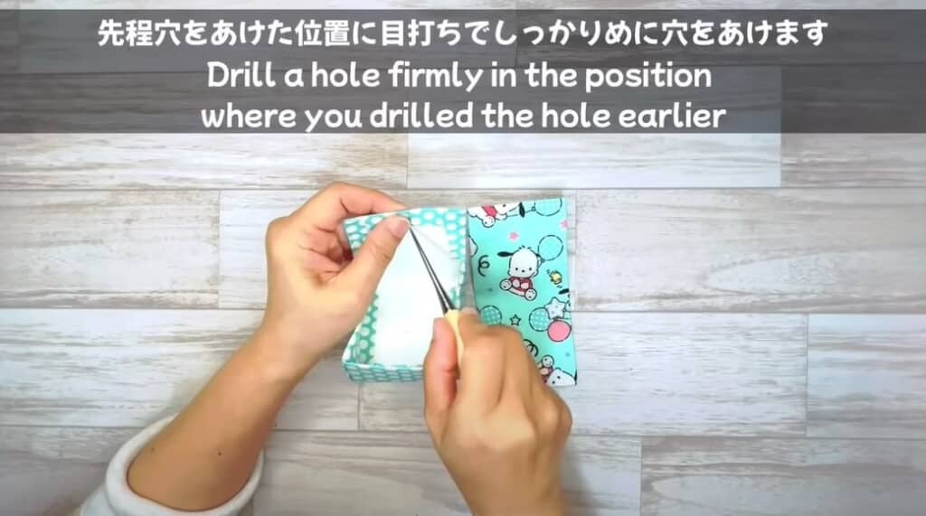 先ほどパンチで穴をあけた位置に目打ちで穴をあけます