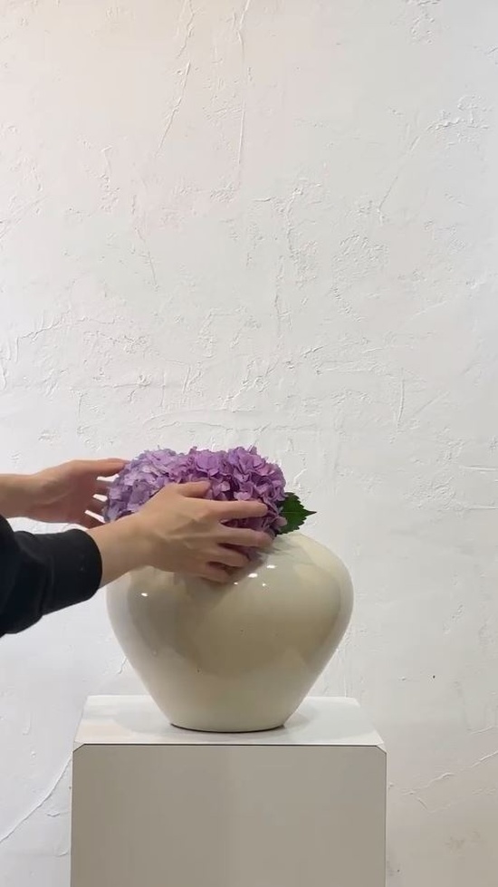 シンプルなアイボリーの花器に生けます