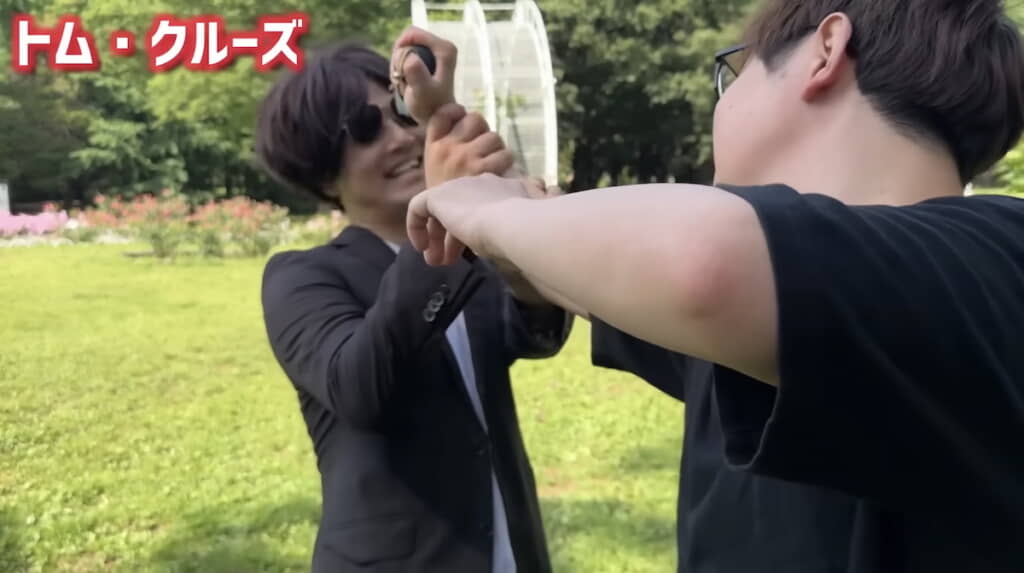 格闘中に余裕の笑みを見せるトム
