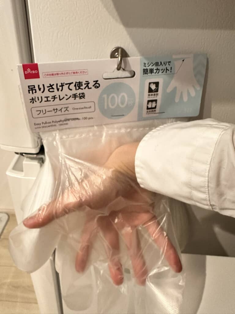 ダイソーのビニール手袋に手を突っ込んでいるところ
