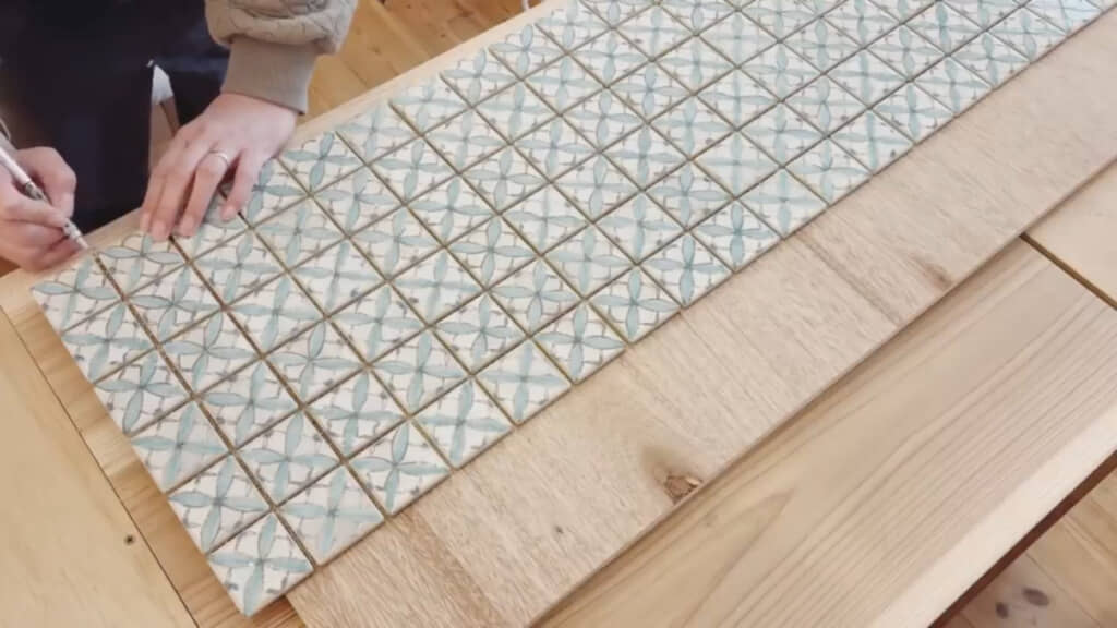 板の上にタイルを並べてカットする位置に印をつけて