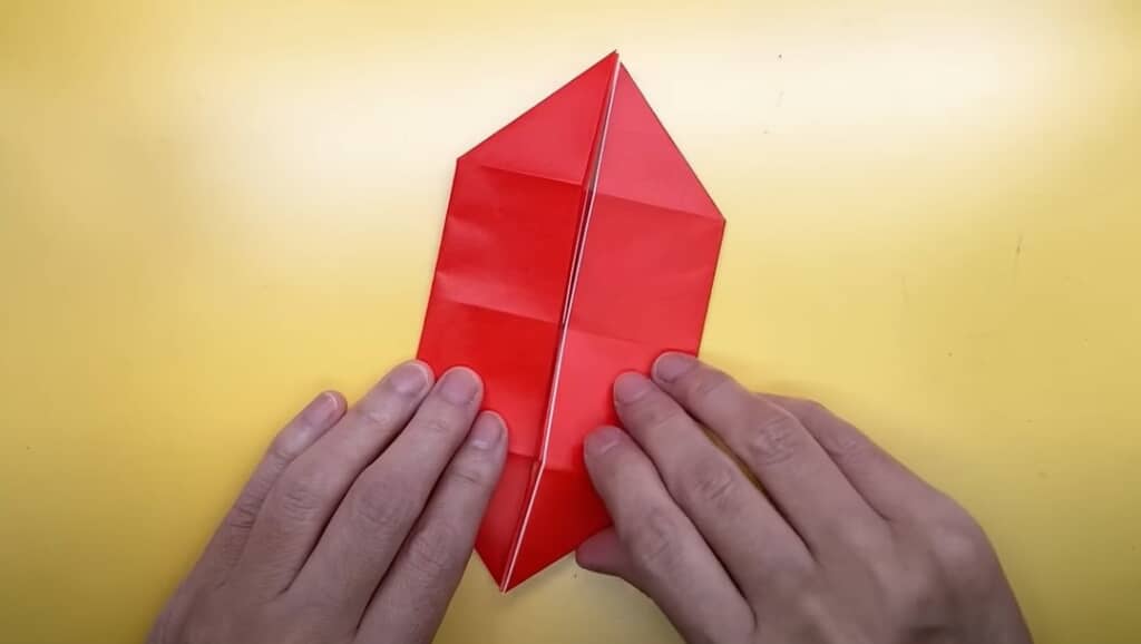 赤い折り紙を船のような形に折ります
