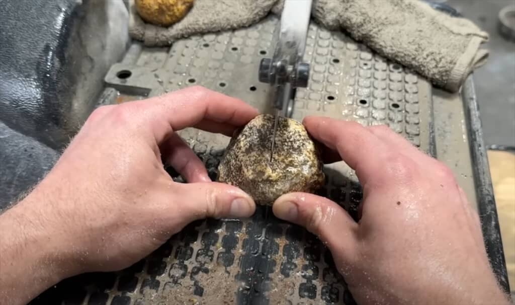 電動のこぎりで原石を真っ二つにカット