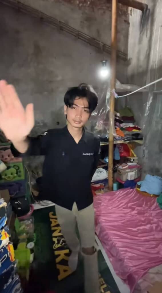 男性がカメラに向けて手をかざしている