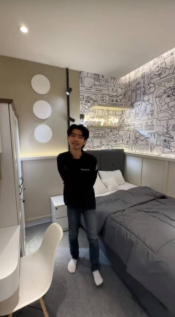 男性が綺麗な部屋で腕を背で組んでいる