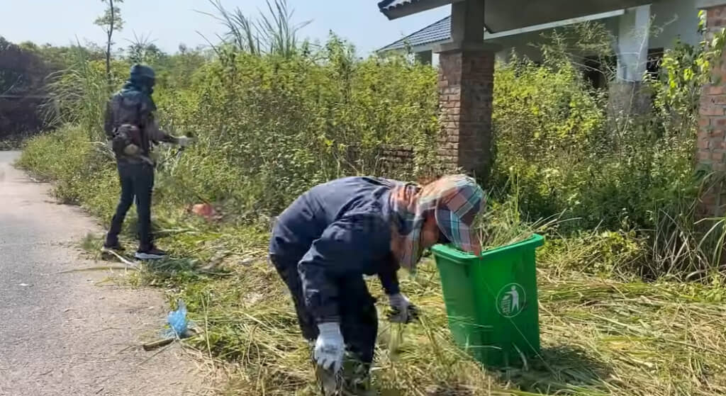 家の周囲を草刈り機で刈り取る