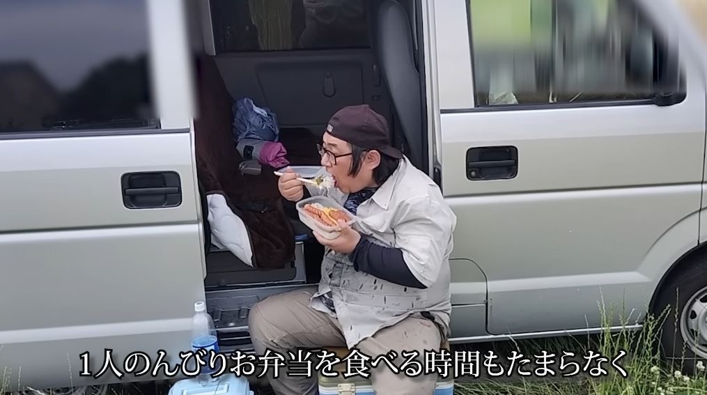 駐車場でウインナー弁当を食べるまさおさん