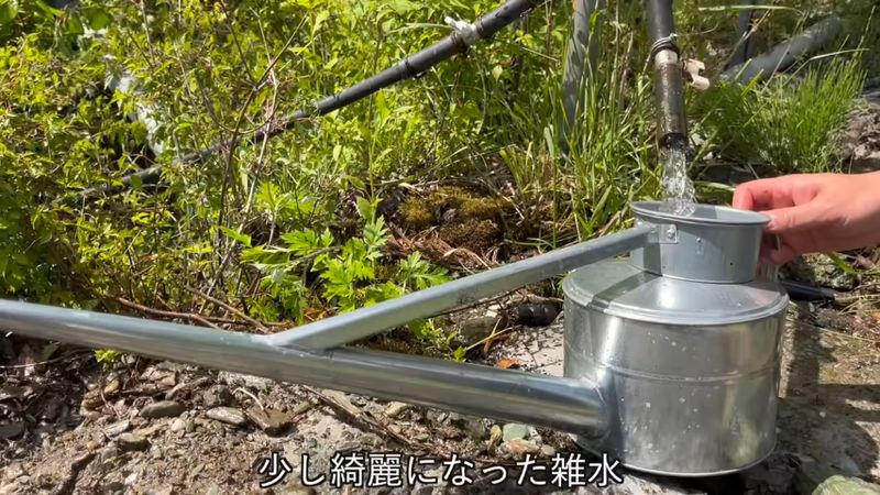 水槽経由で流れ出てきた水をじょうろでくむ
