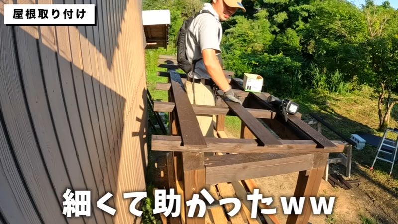 建材の隙間から体を出して野地板を張る