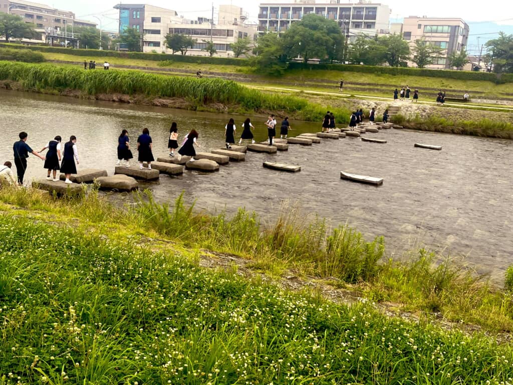 川を渡っていく学生たち
