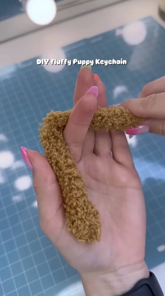 茶色のふわふわなモールを指に巻き付ける