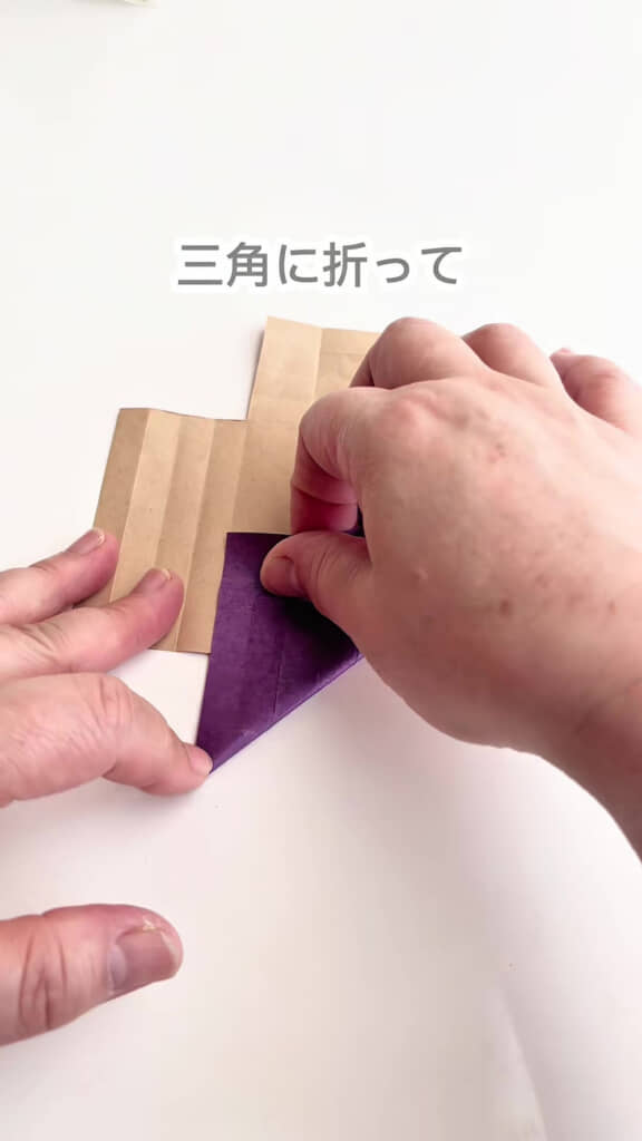 折り紙を三角に折って折り目を入れるところ