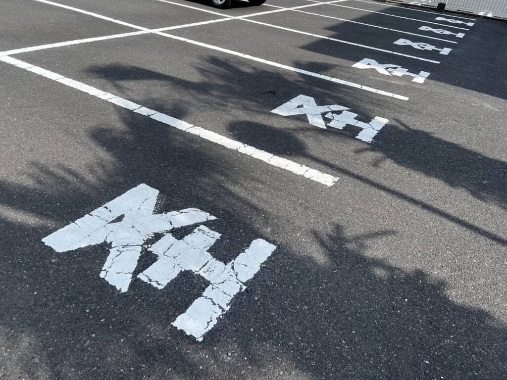 「軽」の略字として又と土だけが書かれている駐車スペース