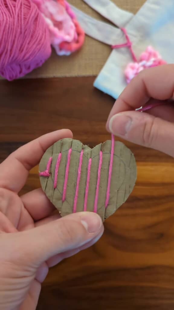 段ボールに毛糸を通します