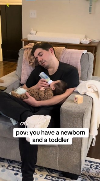 赤ちゃんにミルクをあげながら寝るパパ