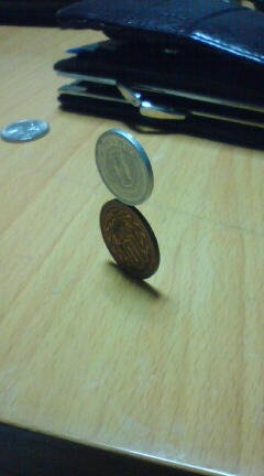 縦置きした10円玉の上に1円玉を乗せた2012年の作品