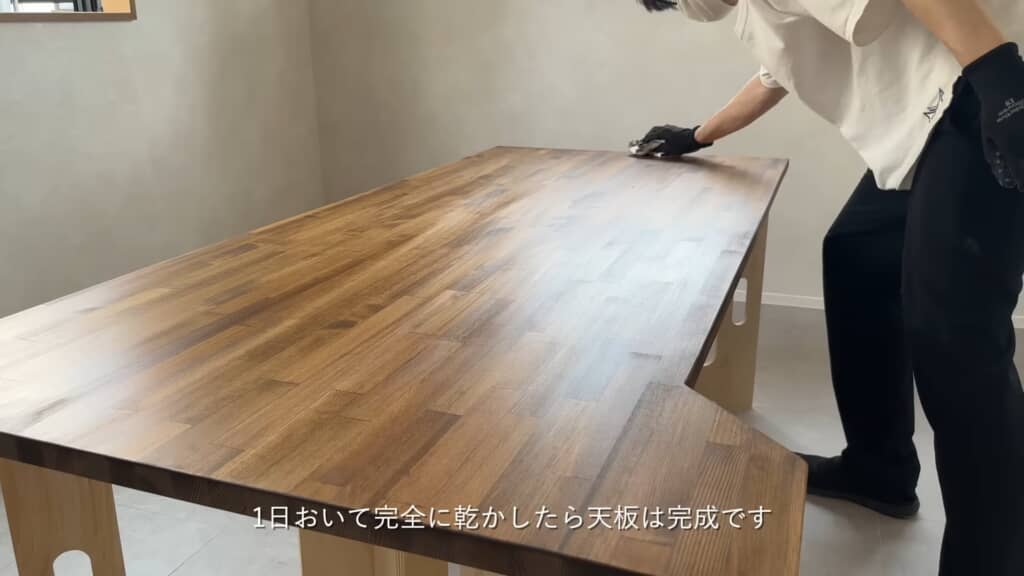 オイル仕上げされた天板を拭き上げる作業中の様子
