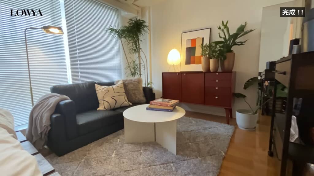 ソファとラグ、観葉植物を配置した落ち着きのあるリビングスペースの完成後の様子。