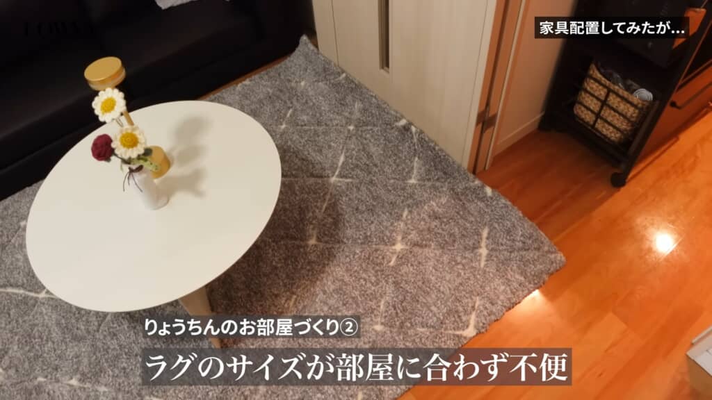 サイズが合わず浮いているグレーのラグと丸テーブルの一部を上から見た様子。