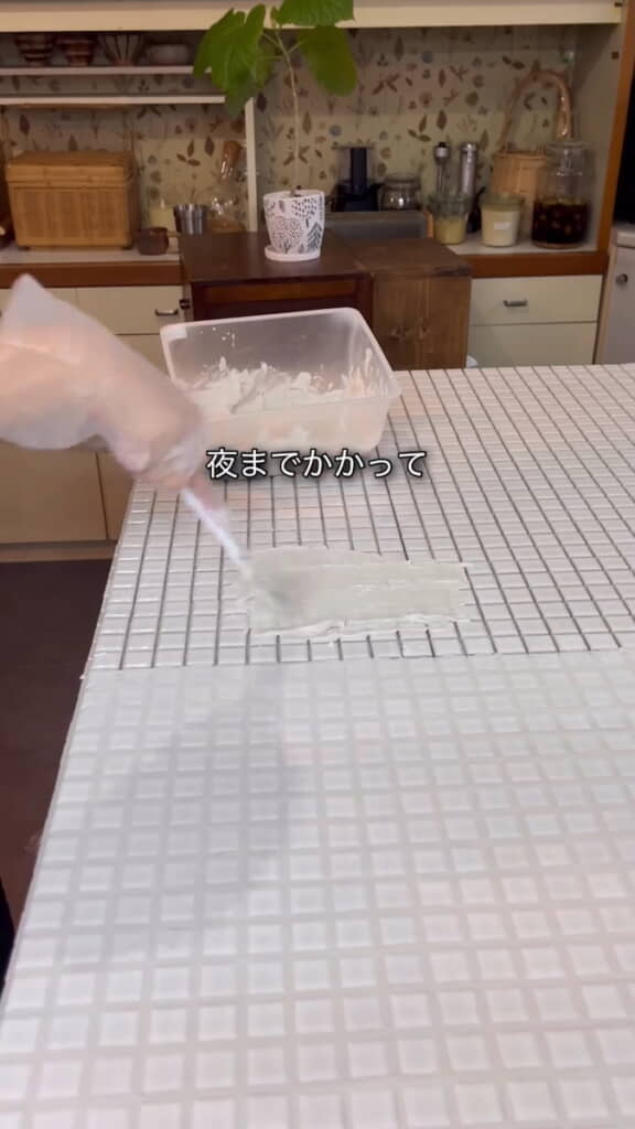 ゴムべらで目地材を埋めていく