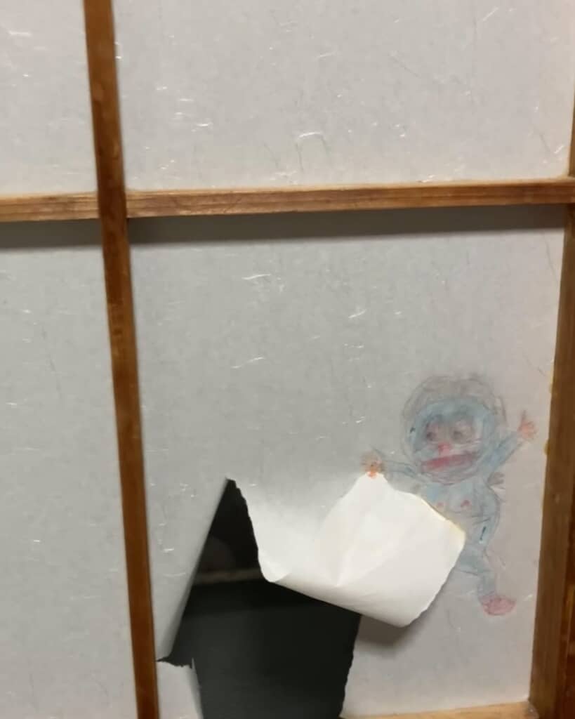 破れをぴらっとめくっているドラえもん風キャラ