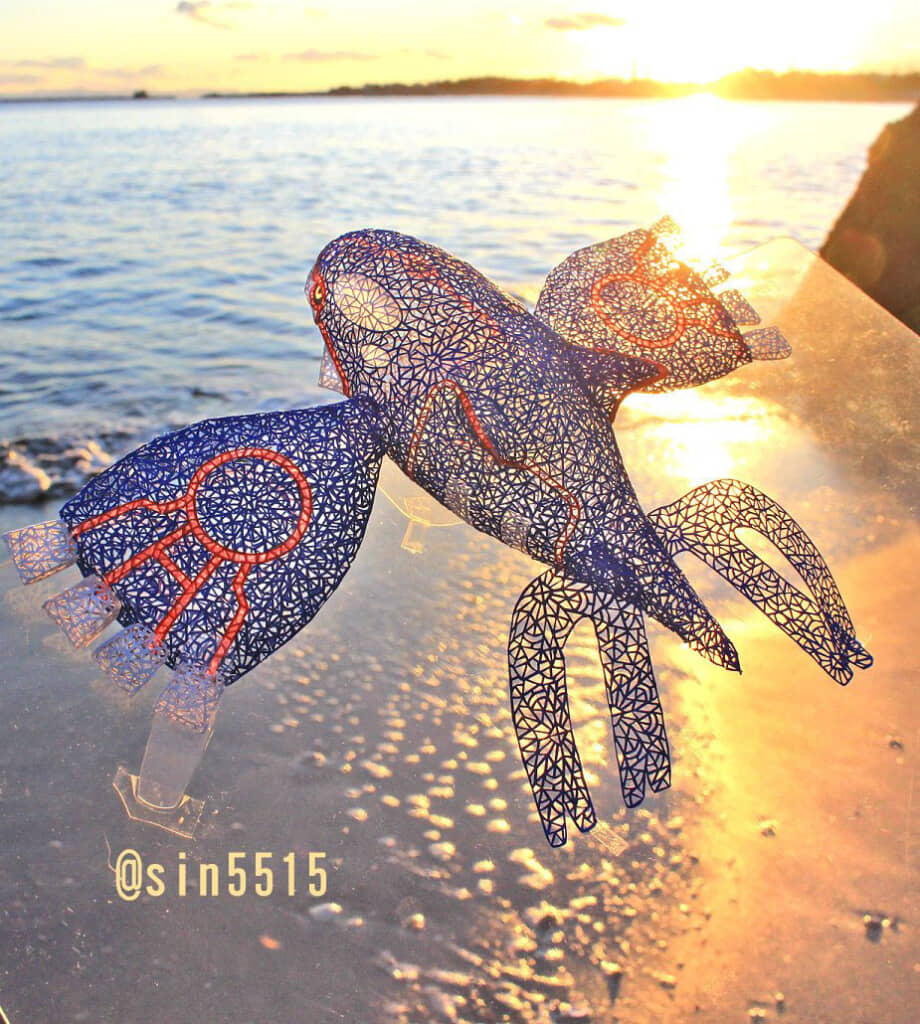 夕暮れの海辺で撮影された、繊細な切り絵アート作品の展示。