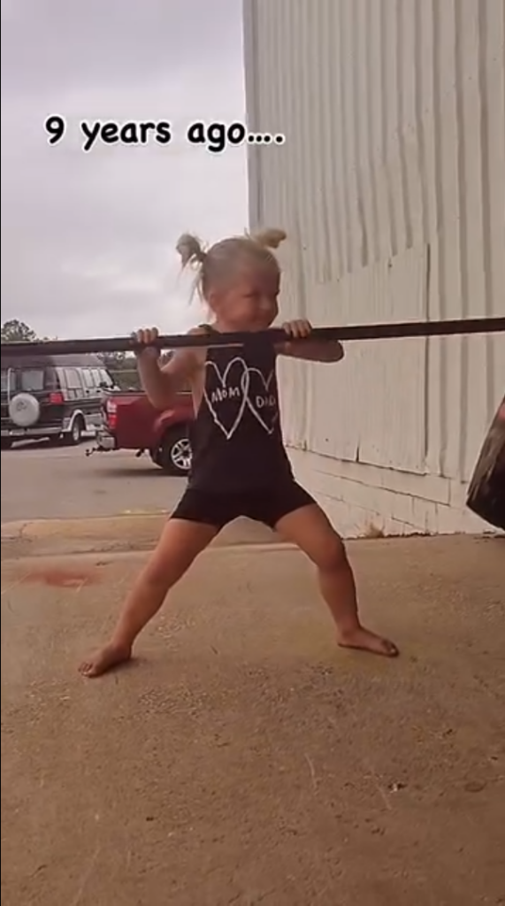 重量挙げのマネをする女の子