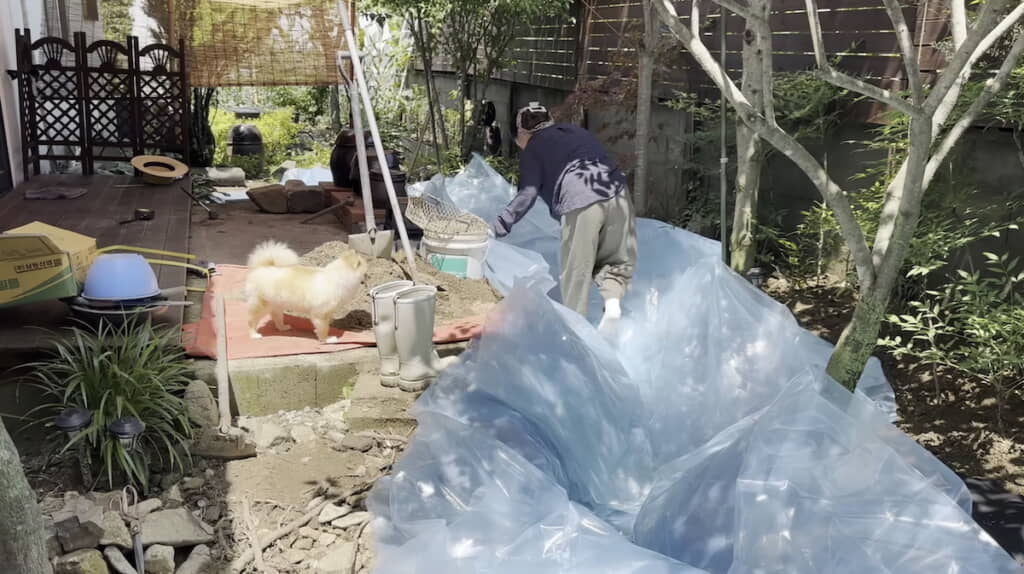 防草シートの上にビニールを敷き詰めていく