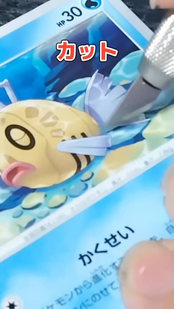 ナイフでヒンバスの絵をカードから切り抜く様子