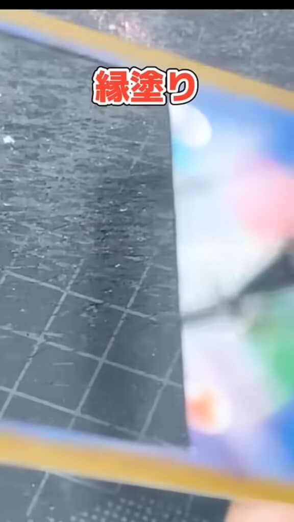 切り抜かれたカードの縁を筆ペンで黒く塗る