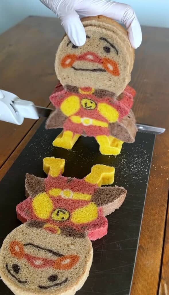 ナイフでパンをカットしている様子。切り口はアンパンマンの形になっている