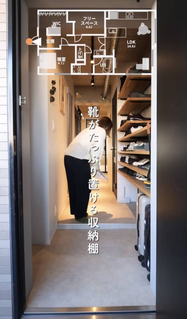 木製ラックに多様な靴が並び、廊下にはアートと照明が配置されている。