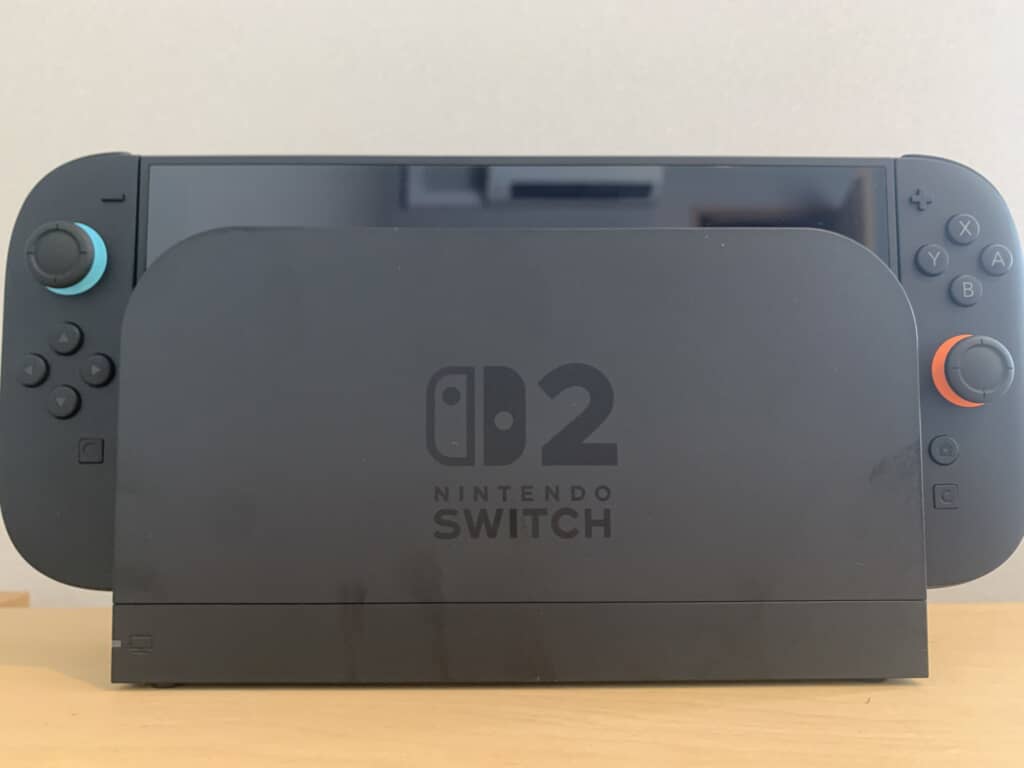 「02」ロゴ入りドックとカラフルなスティックのNintendo Switch。