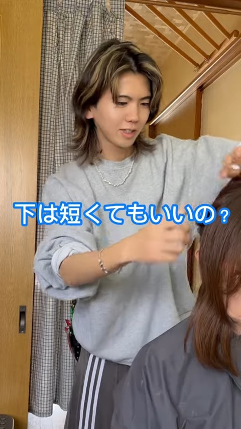 「下は短くてもいいの？」と尋ねながらカットの長さを調整している美容師の息子の姿。