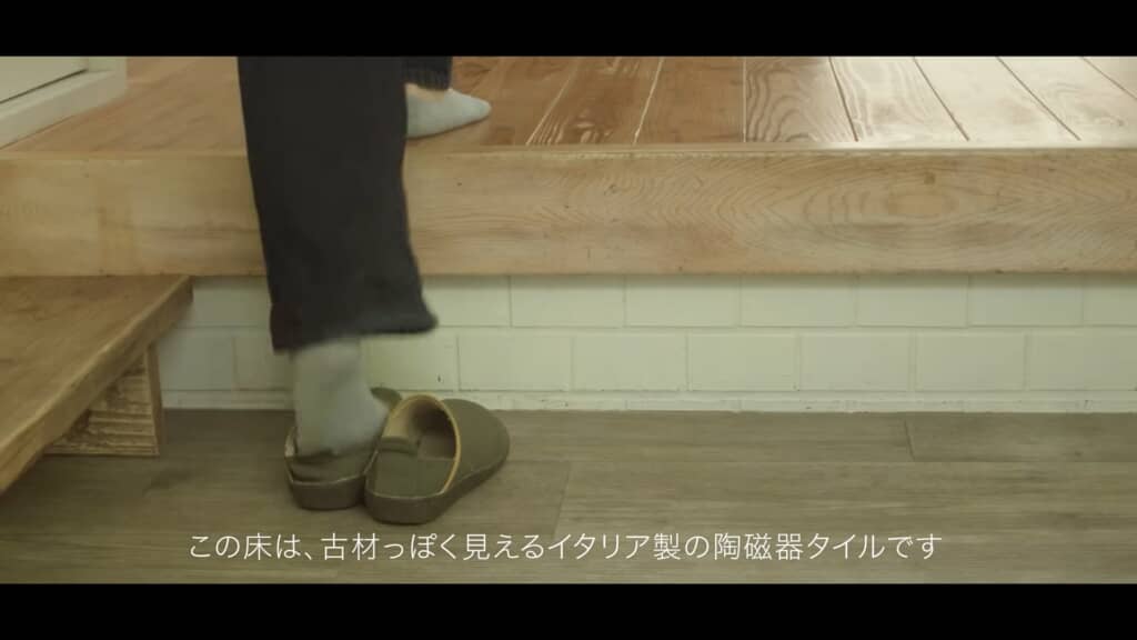 玄関で靴を脱いで上がる女性