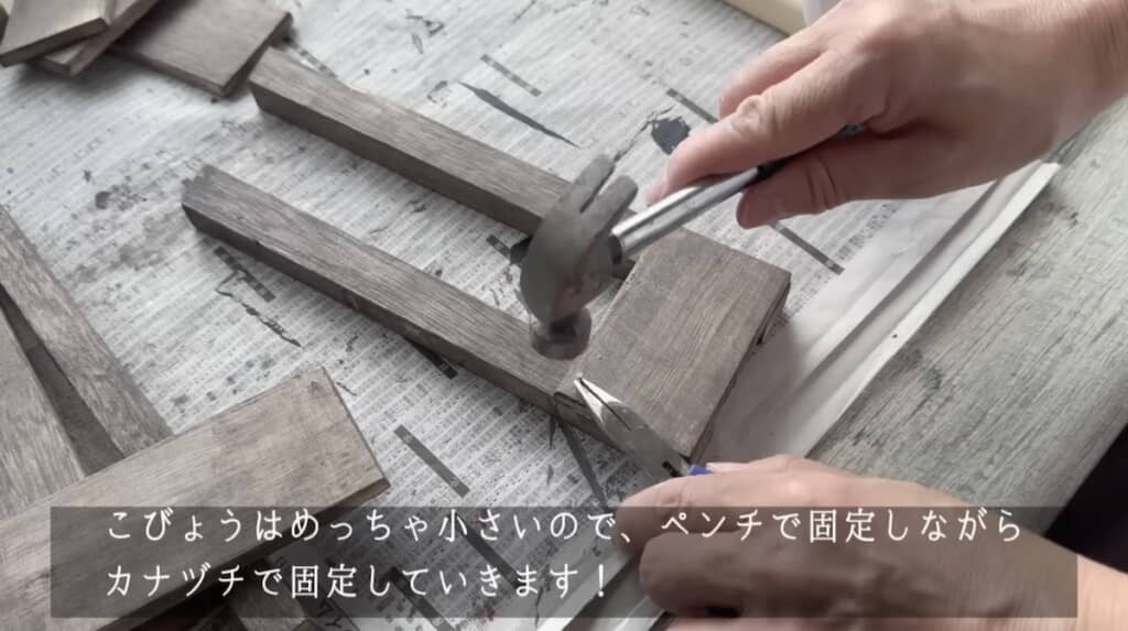 こびょうをペンチで押さえてカナヅチで打ち付ける
