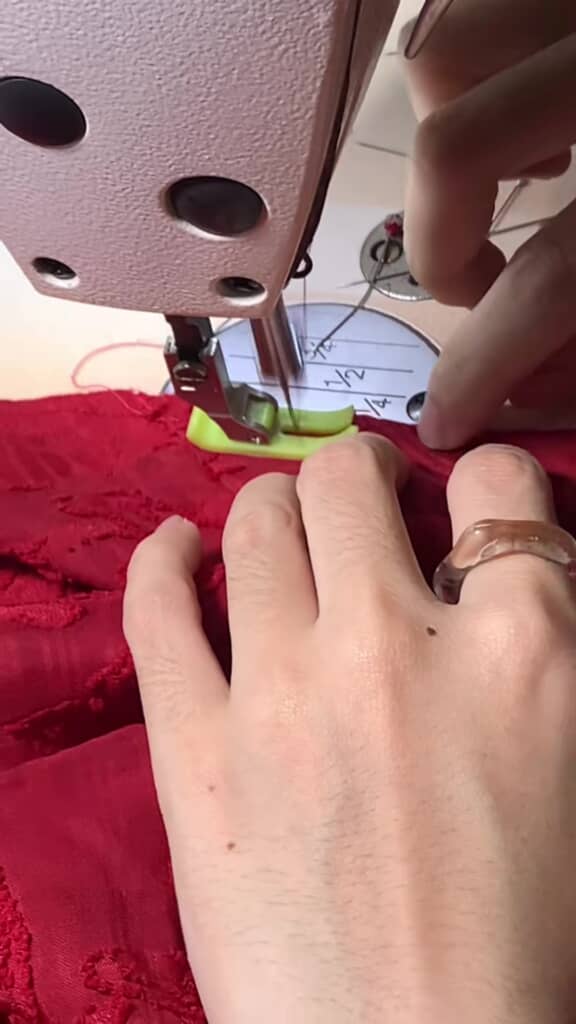 赤い布をミシンで縫うところ