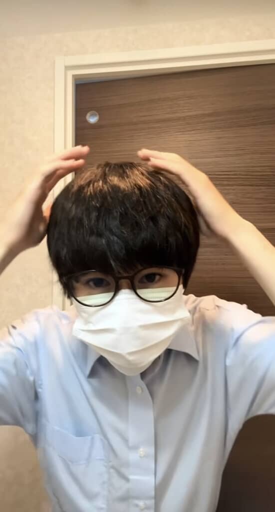 黒髪の男性が髪の毛を整えている