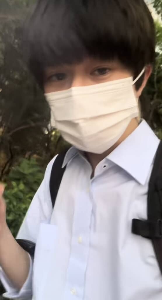 黒髪マスクの男性がメガネを外している