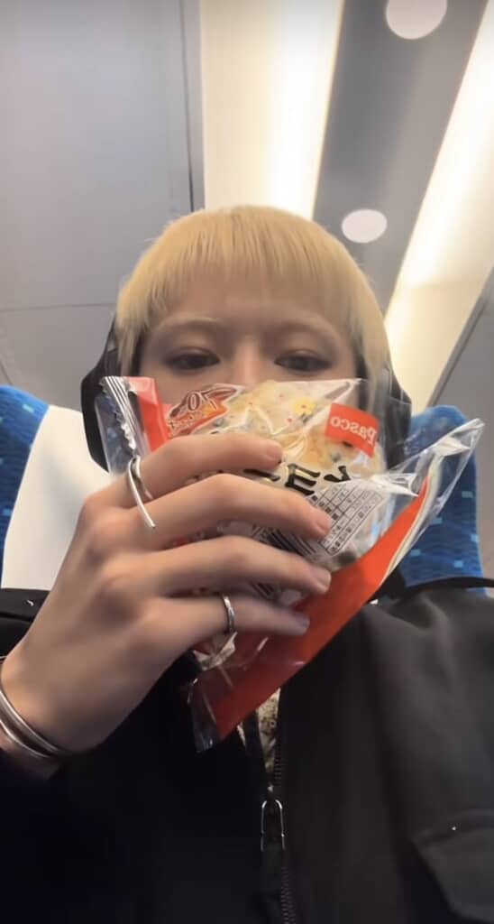 金髪の男性が座ってパンを食べている